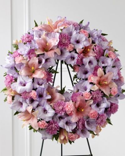 <p data-start="125" data-end="511">When words fall short, flowers speak the language of love, remembrance, and heartfelt connection. The <em data-start="282" data-end="311">FTD® Beloved Friend™ Wreath</em> offers a graceful and moving tribute to someone who touched many lives. Thoughtfully designed in soft pinks and purples, this wreath is a stunning symbol of friendship, affection, and eternal memory.</p>
<p data-start="513" data-end="898">This standing wreath features a balanced blend of lavender gladiolus, blush pink lilies, gentle pink carnations, and other seasonal accents. The circular shape represents continuity and everlasting love, making it a fitting choice for a memorial service, funeral, or celebration of life. Every bloom is carefully placed to convey peace, dignity, and compassion during a time of sorrow.</p>
<p data-start="900" data-end="1238">Ideal for honoring a dear friend or beloved family member, this floral wreath is more than just a decoration—it is a visible expression of gratitude and shared grief. It stands tall beside the casket or altar, offering comfort to those in attendance and celebrating the warmth and kindness that defined the life of the one who has passed.</p>
<p data-start="1240" data-end="1645">Handcrafted with care by expert florists at Rosa’s La Hacienda in Boca Raton, each <em data-start="1323" data-end="1347">Beloved Friend™ Wreath</em> is made to order using fresh, premium blooms. We provide same-day delivery to local funeral homes and churches throughout Boca Raton and the surrounding area. Our team ensures every detail is handled with respect and sensitivity, delivering your tribute on time and with the reverence it deserves.</p>
<p data-start="1647" data-end="1966">If you’re looking for a beautiful way to say farewell to someone who felt like family, the <em data-start="1738" data-end="1762">Beloved Friend™ Wreath</em> captures the spirit of lasting friendship and heartfelt love. It’s a floral remembrance that brings a gentle presence to a somber day—and a lasting memory for those who gather to honor a life well lived.</p>