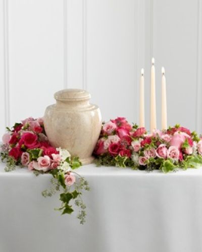<p data-start="162" data-end="573"><strong data-start="162" data-end="240">The FTD® Remembrance® Arrangement – A Graceful Tribute of Beauty and Light</strong><br data-start="240" data-end="243" />Celebrate a life filled with love and kindness through The FTD® Remembrance® Arrangement, a beautifully designed floral display that surrounds the urn with elegance and warmth. Created to bring comfort and serenity to a final farewell, this sophisticated arrangement honors a loved one with graceful blooms and gentle candlelight.</p>
<p data-start="575" data-end="962">Fuchsia and pale pink roses, along with matching spray roses, form the heart of this design. The roses are accented with lush greenery and arranged to gently wind around the base of the urn, creating a soft and natural setting that reflects tenderness and care. Three ivory taper candles are positioned within the florals, casting a soft glow that adds peace and reverence to the moment.</p>
<p data-start="964" data-end="1271">This arrangement is ideal for memorials, celebration of life services, or any cremation ceremony where you wish to highlight the urn with beauty and meaning. Its circular form is symbolic of eternal love, while the combination of color and candlelight creates a comforting atmosphere for friends and family.</p>
<p data-start="1273" data-end="1602">Handcrafted with care by Rosa’s La Hacienda in Boca Raton, each Remembrance® Arrangement is made fresh to order and carefully delivered to the funeral home or service location. We offer same-day delivery throughout Boca Raton and nearby communities, working closely with local venues to ensure timely and respectful presentation.</p>
<p data-start="1604" data-end="1843">Want to include a personal message? Add your note during checkout and we’ll ensure it accompanies your tribute with dignity. The FTD® Remembrance® Arrangement is a thoughtful way to express love, offer comfort, and honor a life well lived.</p>
<p data-start="1845" data-end="2027">Order today from Rosa’s La Hacienda and let us help you create a lasting tribute with flowers that speak from the heart. Same-day delivery available for local services in Boca Raton.</p>