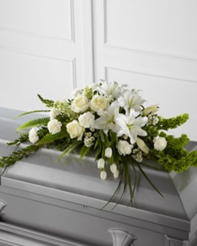 <p data-start="164" data-end="571"><strong data-start="164" data-end="247">The FTD® Resurrection™ Casket Spray – A Symbol of Peace, Hope, and Eternal Life</strong><br data-start="247" data-end="250" />Offer a message of comfort and renewal with The FTD® Resurrection™ Casket Spray, a graceful floral tribute designed to inspire serenity and remembrance. With its uplifting blend of white blooms and vibrant green accents, this arrangement speaks to the beauty of life, the depth of love, and the hope of everlasting peace.</p>
<p data-start="573" data-end="978">This elegant casket spray features white tulips, roses, snapdragons, Oriental lilies, larkspur, carnations, and monte casino asters. Bright green Bells of Ireland add height, movement, and a sense of promise, while a variety of premium greenery brings texture and fullness to the display. Arranged with care, the design flows softly across the casket, offering a peaceful presence during a final farewell.</p>
<p data-start="980" data-end="1287">Ideal for traditional services, memorials, or celebration of life ceremonies, The FTD® Resurrection™ Casket Spray reflects purity, spiritual renewal, and the dignity of the occasion. Its white and green color palette is timeless and symbolic—white for peace and reverence, green for growth and eternal life.</p>
<p data-start="1289" data-end="1676">Each arrangement is handcrafted by the floral artisans at Rosa’s La Hacienda in Boca Raton. We take great care in preparing every order fresh, ensuring that your tribute arrives in pristine condition and is delivered with respect. We work directly with local funeral homes to coordinate delivery and placement, offering same-day service throughout Boca Raton and surrounding communities.</p>
<p data-start="1678" data-end="1953">Want to include a message of condolence? Add your personal note during checkout and we will ensure it is delivered with your floral arrangement. The FTD® Resurrection™ Casket Spray is a meaningful way to honor the memory of someone who brought light and grace into the world.</p>
<p data-start="1955" data-end="2133">Order today from Rosa’s La Hacienda for same-day funeral flower delivery in Boca Raton, and let us help you offer peace and remembrance with a tribute that speaks from the heart.</p>