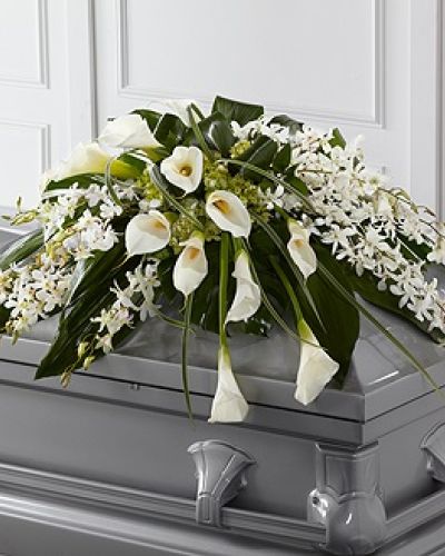 <p data-start="160" data-end="606">Honor a loved one with elegance and tranquility through The FTD® Angel Wings™ Casket Spray. This exquisite arrangement is designed to bring a sense of peace and beauty to the final farewell, with its soft color palette and flowing, airy design evoking a quiet reverence. It’s a dignified and heartfelt tribute to someone who brought grace and love to those around them.</p>
<p data-start="608" data-end="993">The spray features a sophisticated blend of white Dendrobium orchids and elegant calla lilies, paired with green hydrangea and a lush mix of seasonal greenery. These premium blooms are carefully arranged to rest gracefully atop the casket, creating a full, sweeping design that feels light yet profoundly moving. The soft whites and greens symbolize purity, serenity, and eternal love.</p>
<p data-start="995" data-end="1293">Ideal for funeral services, memorials, or celebration of life ceremonies, The FTD® Angel Wings™ Casket Spray is perfect for honoring a loved one known for their gentle spirit, calming presence, or unwavering strength. Its refined composition speaks volumes in a moment where words often fall short.</p>
<p data-start="1295" data-end="1666">Each arrangement is handcrafted by the experienced florists at Rosa’s La Hacienda in Boca Raton. We take care with every detail to ensure the flowers arrive fresh, beautifully styled, and in perfect condition. Same-day delivery is available throughout Boca Raton and surrounding communities, and we coordinate directly with local funeral homes to ensure seamless service.</p>
<p data-start="1668" data-end="1920">Want to include a heartfelt note? Add your message during checkout and we will ensure it is delivered alongside your arrangement with care and compassion. The FTD® Angel Wings™ Casket Spray provides a lasting expression of love, remembrance, and peace.</p>
<p data-start="1922" data-end="2074">Order today from Rosa’s La Hacienda for same-day funeral flower delivery in Boca Raton and let us help you honor a cherished life with grace and beauty.</p>
