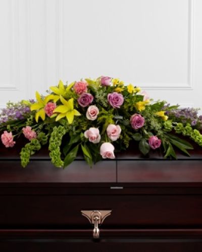 <p data-start="137" data-end="441">When it’s time to say goodbye, only the most radiant tribute will do. The FTD® Forever Beloved™ Casket Spray is a vivid and elegant expression of enduring love, designed to bring comfort, light, and beauty to a final farewell.</p>
<p data-start="443" data-end="927">This lush and full casket spray overflows with a rich variety of blossoms in pastel tones and warm yellows, offering a visual symphony of peace and remembrance. Soft lavender roses, delicate pink roses, and lavender larkspur evoke affection and serenity, while cheerful yellow Asiatic lilies and golden freesia bring an uplifting sense of hope and renewal. Pink carnations, Bells of Ireland, and golden solidago complete the arrangement, adding texture, dimension, and symbolic depth.</p>
<p data-start="929" data-end="1193">Each bloom is carefully placed among fresh, verdant greens to create a generous floral display that spans the casket with grace and harmony. The combination of colors and flowers represents the many layers of a life well lived—tenderness, joy, grace, and strength.</p>
<p data-start="1195" data-end="1481">The FTD® Forever Beloved™ Casket Spray is ideal for honoring someone known for their gentle heart, vibrant spirit, or unwavering devotion to family and friends. It’s a fitting choice for a beloved matriarch or patriarch, or anyone who brought warmth and beauty into the lives of others.</p>
<p data-start="1483" data-end="1811">Hand-arranged and delivered with care by Rosa’s La Hacienda, your trusted local florist in Boca Raton, this tribute ensures every detail is handled with reverence. Whether delivered to a church, funeral home, or graveside service, this spray offers an unforgettable floral expression of love, remembrance, and deep appreciation.</p>
<p data-start="1813" data-end="1952">Let this exquisite tribute serve as a final gift—one that celebrates cherished memories and brings a measure of peace to those left behind.</p>