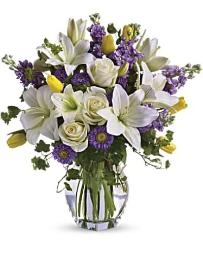 <p>Welcome the gentle awakening of spring with a bouquet that feels like a breath of fresh air. This graceful arrangement captures the season’s beauty with soft pastels, delicate textures, and an uplifting energy that brightens both spaces and spirits. It’s an elegant choice for celebrating life’s simple joys, sending warm wishes, or marking a meaningful occasion.</p>
<p>A soft blend of white Asiatic lilies, creamy roses, golden tulips, and shades of lavender stock and matsumoto asters gives the bouquet its timeless charm. Each bloom offers a unique shape and hue, creating a harmonious dance of light and color. Accents of bupleurum, ivy, and seeded eucalyptus add natural depth, while a tall clear glass vase enhances the airy, flowing silhouette of the arrangement.</p>
<p>This design evokes the feel of a walk through a blooming garden—quiet, refreshing, and full of promise. Its calming palette and organic style make it a beautiful centerpiece or an unforgettable gift. Whether placed on a dining table, entryway, or windowsill, it brings the lightness of spring indoors.</p>
<p>Thoughtfully arranged and hand-delivered by a professional florist, this bouquet is crafted using the freshest flowers available. Subtle variations in bloom type or size may occur due to seasonal shifts, but the spirit of the design remains consistently fresh and uplifting. Some blossoms may arrive in bud form, offering the recipient the joy of watching them gently unfold.</p>
<p>Celebrate new beginnings, heartfelt connections, and everyday beauty with a floral gift that perfectly captures the essence of springtime—elegant, joyful, and full of life.</p>