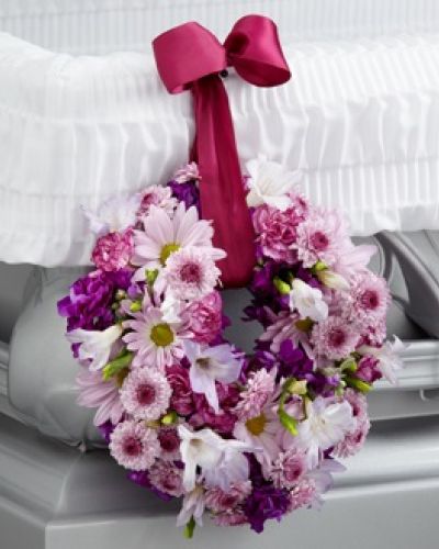 <p data-start="162" data-end="482">When words fall short, a gentle floral tribute can speak volumes. The FTD® Thoughts & Prayers™ Wreath Adornment offers a tender expression of sympathy, symbolizing eternal love and heartfelt prayers in a subtle yet deeply meaningful way.</p>
<p data-start="484" data-end="953">This small yet striking 6-inch wreath features a calming palette of lavender carnations, soft daisies, button poms, and elegant freesia. Each bloom is thoughtfully chosen to represent peace, affection, and grace. Deep magenta stock adds a rich contrast, reflecting the depth of your emotions during a time of loss. The entire arrangement is suspended from a rich burgundy wired ribbon, allowing it to hang gracefully from the side of the casket as a final loving touch.</p>
<p data-start="955" data-end="1288">More than a floral arrangement, this wreath serves as a quiet reminder of the circle of life, the continuity of memory, and the gentle presence of those we’ve lost. It’s perfect for families who want to add a personal, symbolic detail to a memorial setting—one that complements larger sprays or stands without overwhelming the space.</p>
<p data-start="1290" data-end="1574">Appropriate for traditional services, celebrations of life, and quiet family gatherings, this adornment brings comfort and thoughtfulness to the final farewell. Whether you’re honoring a parent, sibling, or close friend, it helps convey lasting affection in a beautifully subtle form.</p>
<p data-start="1576" data-end="1889">Locally crafted and delivered by Rosa’s La Hacienda in Boca Raton, each wreath is arranged with care and sensitivity. As a trusted local florist, we ensure that your sympathy flowers arrive fresh, meaningful, and beautifully composed, so you can focus on what matters most—remembering and honoring your loved one.</p>
<p data-start="1891" data-end="1991">Choose this elegant wreath to share your thoughts and prayers in a way that words alone never could.</p>