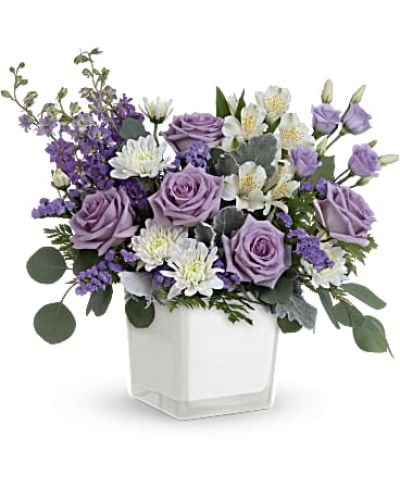 <p data-start="131" data-end="542">Treat someone to a moment of calm, elegance, and luxury with Lavender Blooms—a stunning arrangement that turns any day into a special occasion. With its soft purple tones and graceful silhouette, this bouquet evokes serenity and style in equal measure. Whether you're sending a thoughtful surprise, celebrating a milestone, or simply brightening a space, Lavender Blooms delivers beauty with a whisper of charm.</p>
<p data-start="544" data-end="1044">The bouquet features a soothing blend of lavender roses, airy white alstroemeria, delicate lisianthus, larkspur, and lavender sinuata statice, all accented by white cushion spray chrysanthemums for added fullness and texture. Dusty miller, leatherleaf fern, and silver dollar eucalyptus provide soft greenery that complements the palette while adding structure and balance. Every bloom is hand-selected to ensure freshness and vibrancy, creating a design that feels effortlessly graceful and refined.</p>
<p data-start="1046" data-end="1417">Presented in Teleflora’s Color Splash cube—a modern white glass container with a soft matte finish—this bouquet offers understated sophistication with a versatile look. The cube’s minimalist design makes it easy to reuse as a decorative accent, candle holder, or small vase long after the flowers have faded. It's the perfect pairing of modern style and timeless florals.</p>
<p data-start="1419" data-end="1761">Ideal for birthdays, get well wishes, anniversaries, or even sympathy gestures, Lavender Blooms speaks gently and meaningfully. Its peaceful tones and rich textures make it especially well-suited for creating a sense of comfort, reflection, and appreciation. It’s the kind of gift that says “you’re in my thoughts” without needing many words.</p>
<p data-start="1763" data-end="2067">Each Lavender Blooms arrangement is crafted by hand and personally delivered by a local florist, ensuring a polished and professional presentation. Rosa’s La Hacienda proudly offers this elegant bouquet throughout the Boca Raton area, where every delivery is a reflection of our care and floral artistry.</p>
<p data-start="2069" data-end="2171" data-is-last-node="" data-is-only-node="">Surprise someone with the soft beauty of Lavender Blooms—an arrangement as calming as it is luxurious.</p>